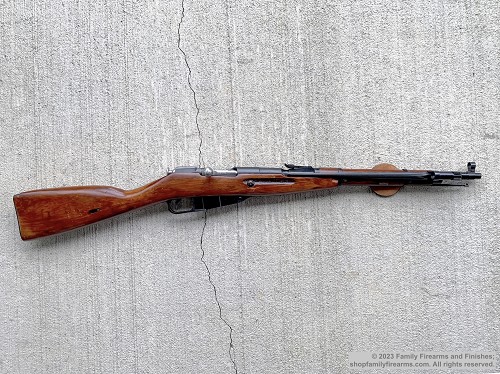 Left profile view of a Russian Mosin-Nagant M44 Izhevsk bolt-action carbine with wooden stock and bayonet folded 