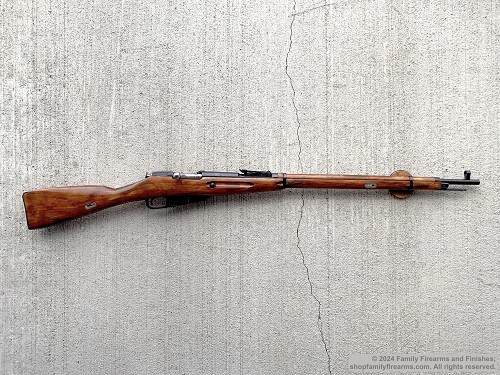 Left profile view of a Russian Mosin-Nagant M91/30 Tula bolt-action rifle with full-length wood stock 