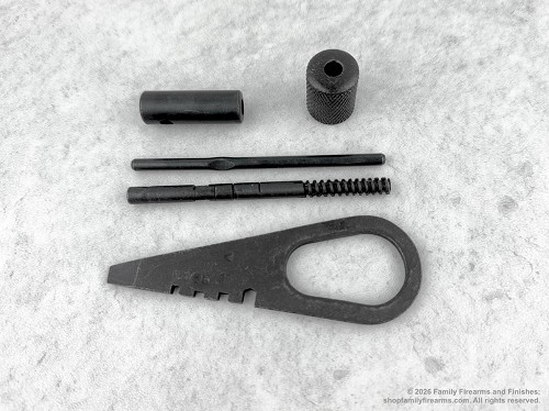 Mosin-Nagant rifle bolt teardown tool shown alongside matching surplus cleaning kit attachments. 