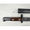 Detailed view of the riveted wooden handle scales and locking mechanism on a vintage Yugoslavian M48 Mauser bayonet 